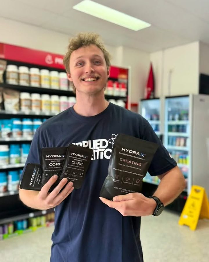 Athlete holding HYDRAX CORE and CREATINE pouches in store
