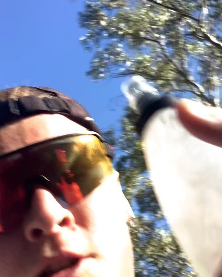 Cyclist drinking from a bottle mid-ride