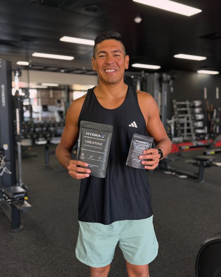 Athlete in the gym holding two HYDRAX pouches