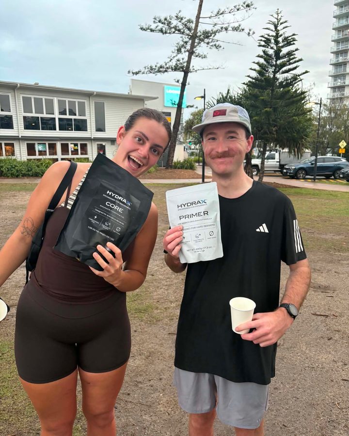 Two runners holding HYDRAX CORE and PRIMER after a club run